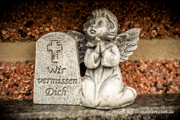 Ein Engel neben einen Gtabtaffel auf der Steht wir vermissen Dich 