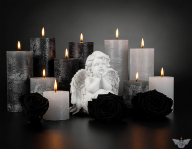Ein Engel inmitten brennender Kerzen und schwarzer Rosen auf einem hellen Hintergrund. Symbol für Gedenken, Trauer und Frieden.