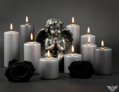 Ein Engel inmitten brennender Kerzen und schwarzer Rosen auf einem hellen Hintergrund. Symbol für Gedenken, Trauer und Frieden.