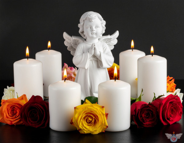 Ein Engel inmitten brennender Kerzen und bunten (gelben, roten, orange)  Rosen auf einem dunklen Hintergrund. Symbol für Gedenken, Trauer und Frieden.