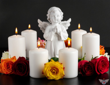 Ein Engel inmitten brennender Kerzen und bunten (gelben, roten, orange)  Rosen auf einem dunklen Hintergrund. Symbol für Gedenken, Trauer und Frieden.