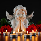 Ein Engel inmitten brennender Teelichtern und roter Rosen auf einem dunklen Hintergrund. Symbol für Gedenken, Trauer und Frieden.